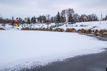a Frozen lake in the park in winter.  The park with lake in city Sumy.