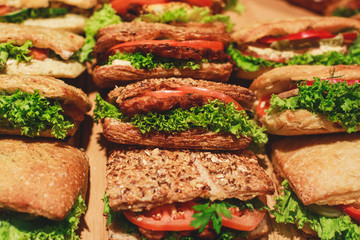 Beautifully decorated catering banquet table with different food snacks and appetizers with sandwich, on corporate christmas birthday kids party event or wedding celebration