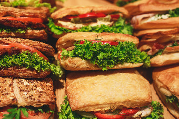 Beautifully decorated catering banquet table with different food snacks and appetizers with sandwich, on corporate christmas birthday kids party event or wedding celebration