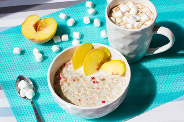 Cereals with milk and fruits. Hot chocolate with marshmallows