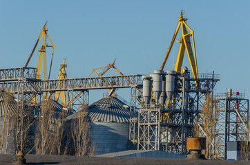 Sea trade port. Grain Terminal. Elevator. Shooting from the shore towards the pier. gantry cranes...