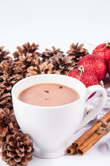 Cup of hot chocolate ,  some cinnamon sticks, cones, christmas balls and candles