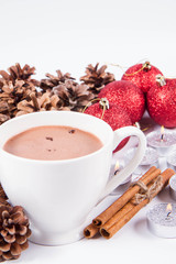 Cup of hot chocolate ,  some cinnamon sticks, cones, christmas balls and candles