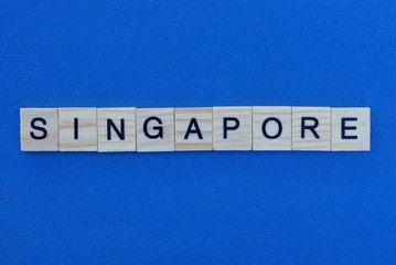 word  singapore from wooden gray letters lies on a blue background