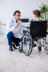 Young male doctor pediatrist and boy in wheel-chair