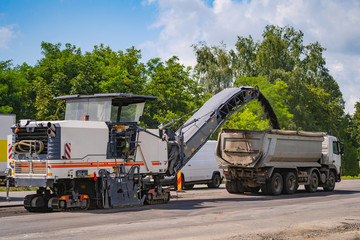 Asphalt spreader in work. Road repair, construction, heavy special machinery.