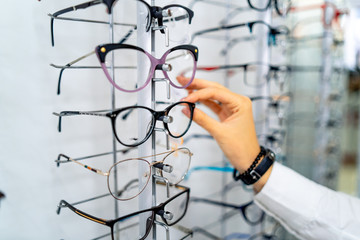 Row of glasses at an opticians. Eyeglasses shop. Stand with glasses in the store of optics. Woman's...