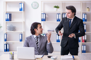 Two young employees working in the office