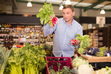 Happy customer buying radish at supermarket
