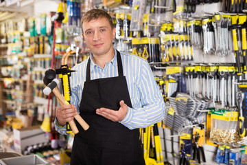 Man seller in apron having tools in hands