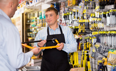 Adult salesman offering tools to man