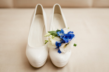 Obraz na płótnie Canvas Wedding accessories in classic blue color: Bride's shoes, rings, boutonniere and wedding bouquet