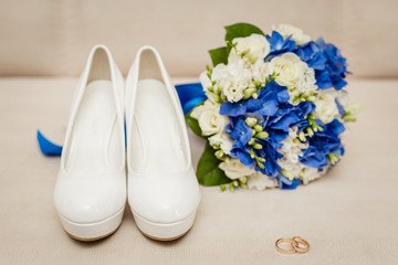 Wedding accessories in classic blue color: Bride's shoes, rings, boutonniere and wedding bouquet
