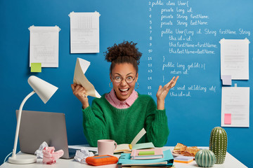 Mad female entrepreneur gets crazy because of much work, screams angrily, holds crumpled paper,...