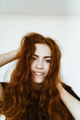 red-haired girl shakes her hair and smiles cute