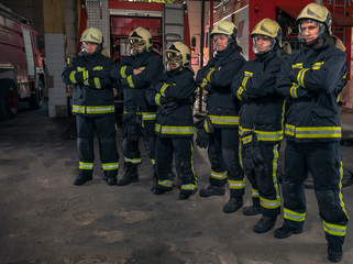 Group of firefighters standing confident with arms crossed. Firemen ready for emergency service.