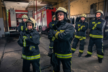 Group of firefighters standing confident with arms crossed. Firemen ready for emergency service.
