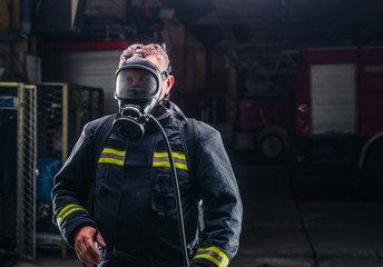 Firefighter with protective uniform wearing oxygen mask