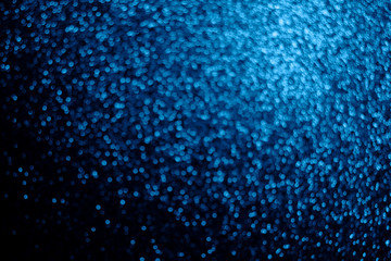 Festive blurry blue background of sequins with side effect.