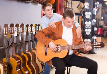 Ordinary teenager and father deciding on guitar