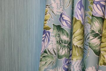 Floral print in cool colors on the curtains against the blue wall.