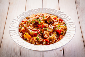 Roast pork meat with rice and vegtables on wooden background