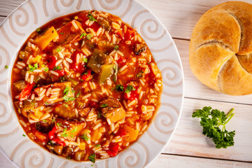 Roast pork meat with rice and vegtables on wooden background