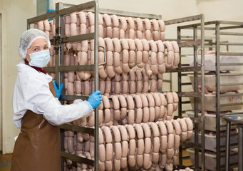 Female carrying sausages on racks