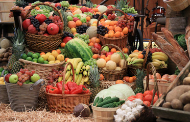 Different kinds of fruits and vegetables placed neatly in baskets on display for thanksgiving.