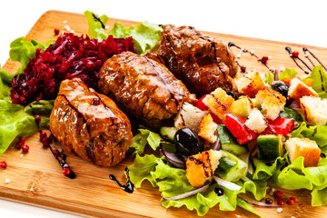 Wrapped pork with vegetables on white background