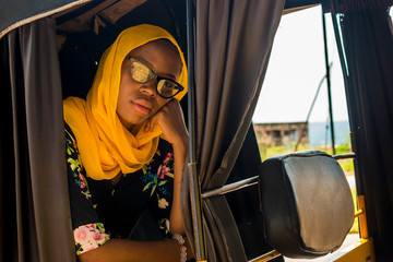 young african woman sitting alone in a rickshaw looking sad and tired