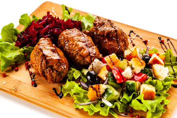 Wrapped pork with vegetables on white background