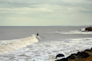 Surfer en la costa un día nublado