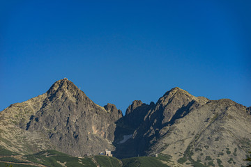 View of the Lomnicky stit (peak), famous rocky summit in High Tatras, Slovakia. Popular peaks Lomnicky stit and Kezmarsky stit on a sunny summer day with blue sky and no clouds.