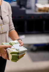Counting person handling stacks of euro € cash at the treasury department