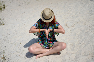 girl on the beach red-haired girl girl in a hat yoga meditation 