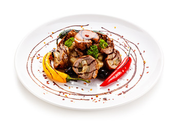 Wrapped pork with vegetables on white background