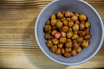plate with nuts on a gray background with scattered hearts