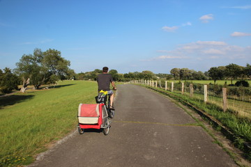 Man with child in bicycle trailer 