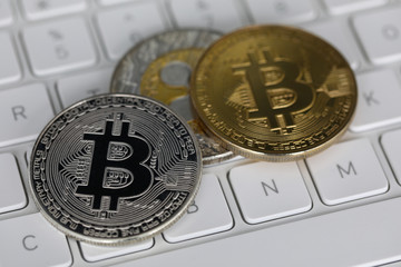 Cryptocurrency metal coins lie on white laptop keyboard.