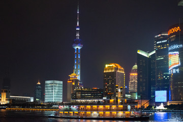 Fototapeta na wymiar Nighttime in Shanghai at the Bund (riverside front) with landmarks from the opposite side of the river (PuDong) with pearl tower and all of them illuminated