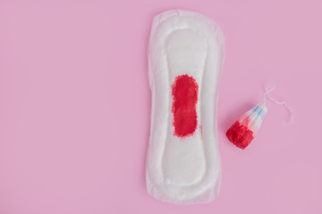 Protective tampon and white pad with blood spots and drops for woman hygiene and care on bright pink background. Cotton swab.