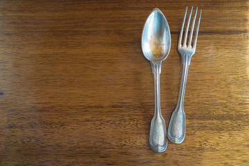 Vintage spoon and fork on the vintage wooden background. Copy space, flat lay