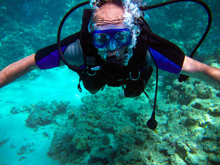 Man scuba diver and beautiful colorful coral reef underwater