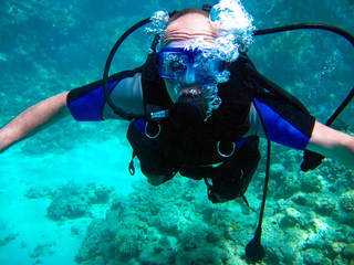 Naklejka na ściany i meble Man scuba diver and beautiful colorful coral reef underwater