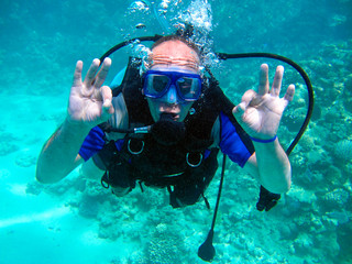 Man scuba diver and beautiful colorful coral reef underwater