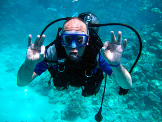 Man scuba diver and beautiful colorful coral reef underwater