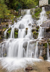 Fototapeta na wymiar A small cascade waterfall, near a village of Encamp, Andorra. Located in the Pyrenees mountain