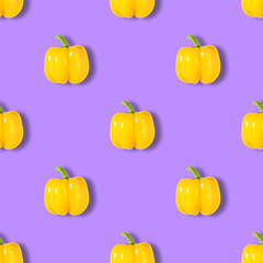 Seamless pattern with yellow pepper on purple background. Vegetable pattern. Abstract background.