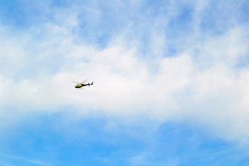 Fototapeta na wymiar A helicopter flies high in the sky. Barcelona, Catalonia, Spain.